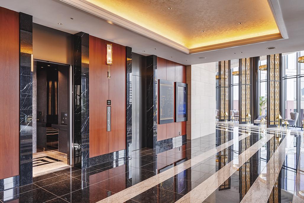 Corporate office lobby with wood-panelled walls and a single elevator
